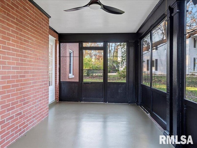 unfurnished sunroom featuring ceiling fan and plenty of natural light