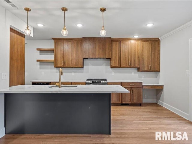 kitchen featuring stainless steel range, light wood-type flooring, hanging light fixtures, and sink