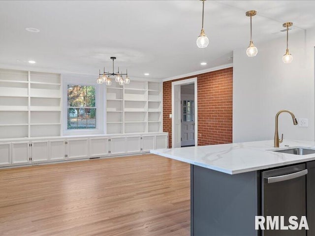 kitchen with sink, pendant lighting, and a center island with sink