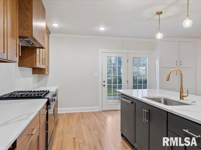 kitchen featuring decorative light fixtures, light stone counters, sink, and appliances with stainless steel finishes