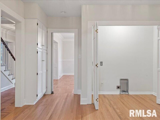 corridor with stairway, light wood-type flooring, and baseboards