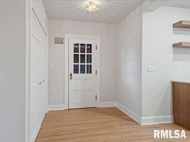 interior space with baseboards, visible vents, and light wood-style floors