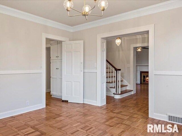 empty room featuring a chandelier, ornamental molding, stairway, and visible vents