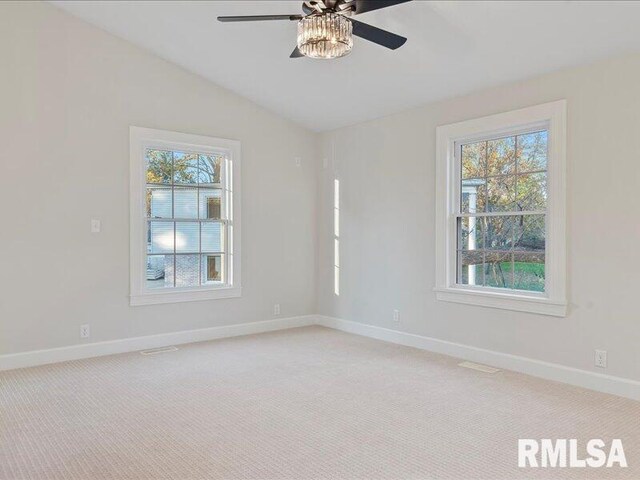 unfurnished room with a ceiling fan, lofted ceiling, light colored carpet, and baseboards