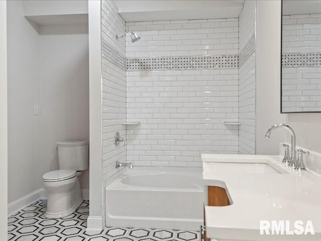 full bathroom featuring toilet, tiled shower / bath, and sink