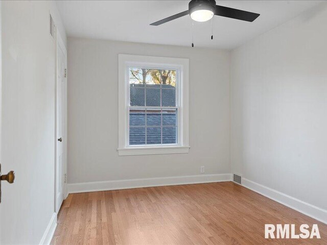 empty room featuring baseboards, a ceiling fan, and light wood-style floors