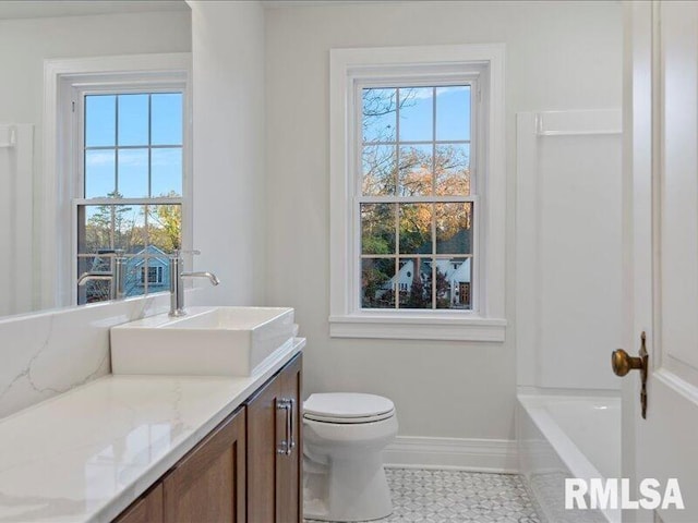 bathroom with toilet, tile patterned floors, vanity, and baseboards