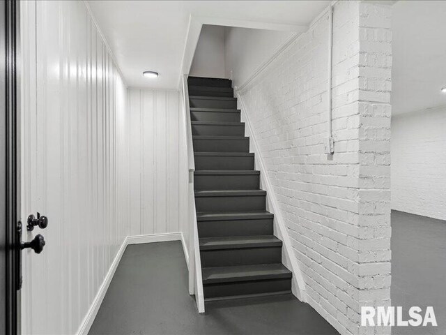 staircase featuring concrete floors