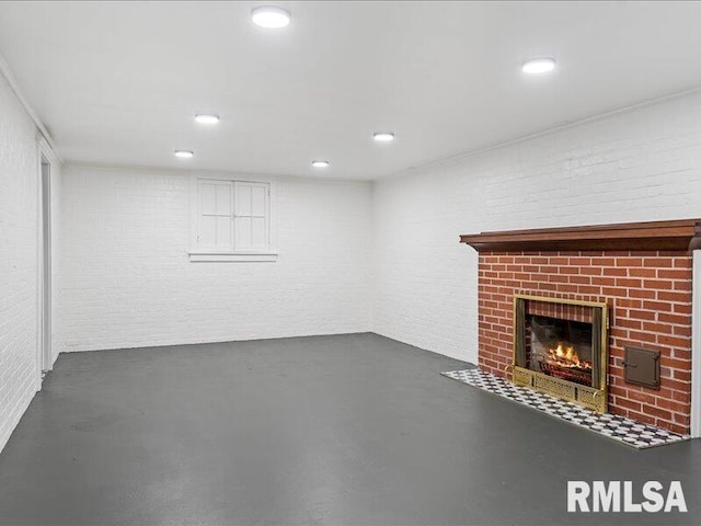 basement with a fireplace and brick wall