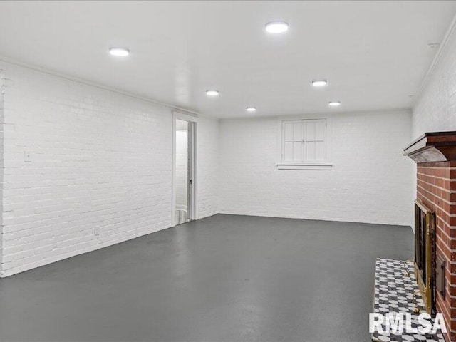 basement featuring brick wall and a brick fireplace