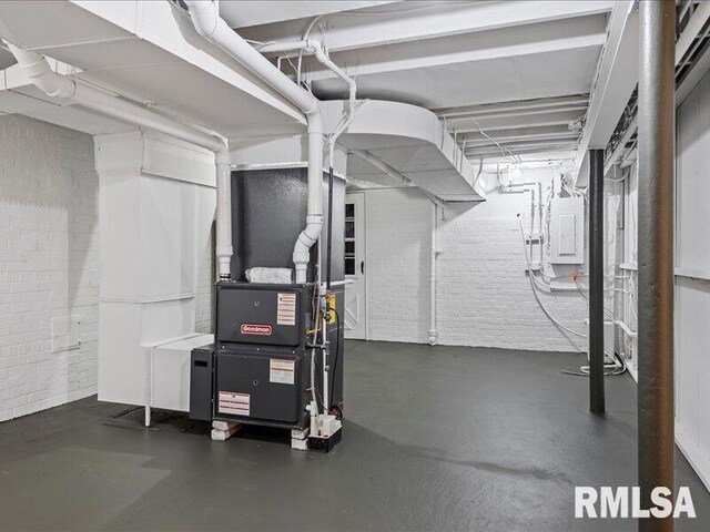 basement with electric panel and brick wall