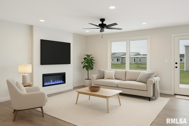 living room with light wood-type flooring, recessed lighting, baseboards, and a healthy amount of sunlight