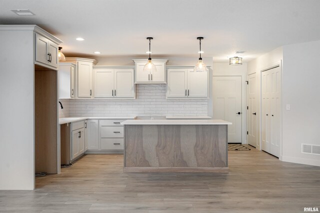 kitchen featuring visible vents, recessed lighting, light wood finished floors, backsplash, and decorative light fixtures
