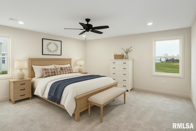 bedroom featuring light colored carpet, baseboards, visible vents, and multiple windows