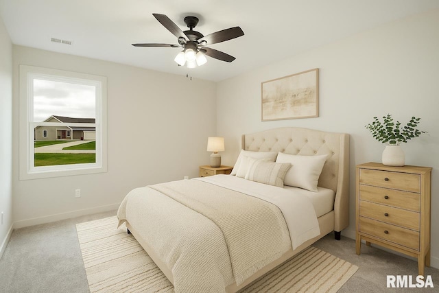 bedroom with a ceiling fan, baseboards, visible vents, and light carpet