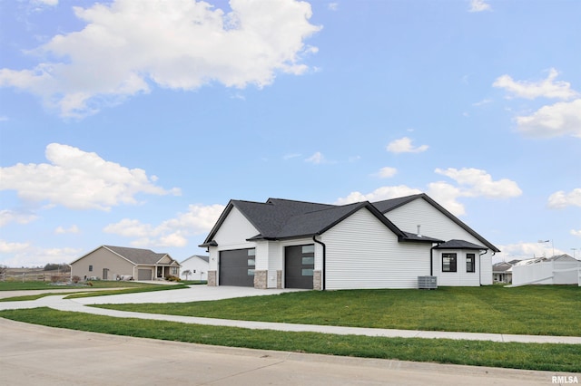 view of front of home with a front yard, a garage, and central air condition unit