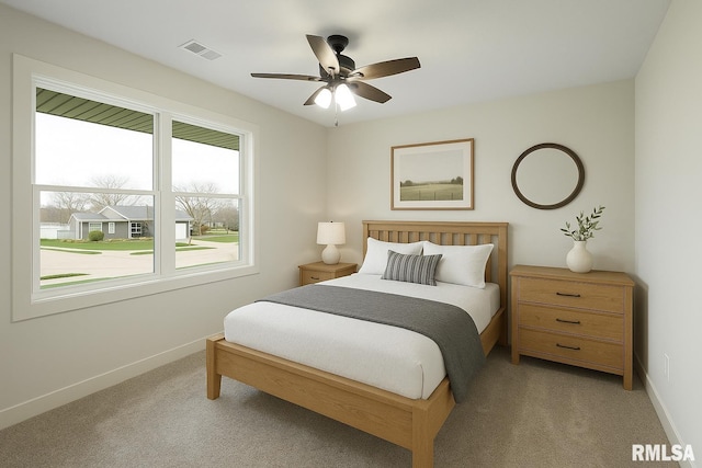 carpeted bedroom with a ceiling fan, baseboards, and visible vents