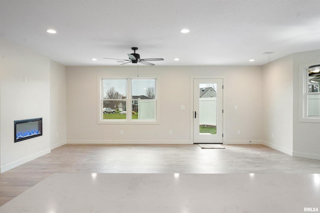 unfurnished living room featuring ceiling fan and light hardwood / wood-style floors