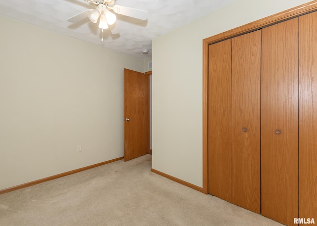 unfurnished bedroom featuring light carpet, a closet, and ceiling fan