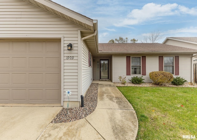 entrance to property featuring a yard and a garage