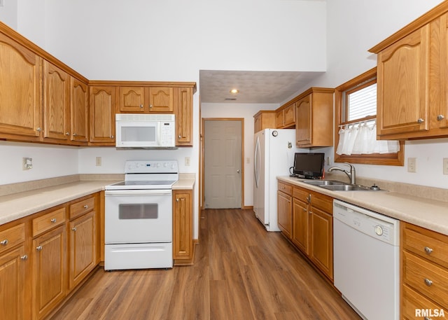 kitchen with white appliances, sink, and dark wood-type flooring