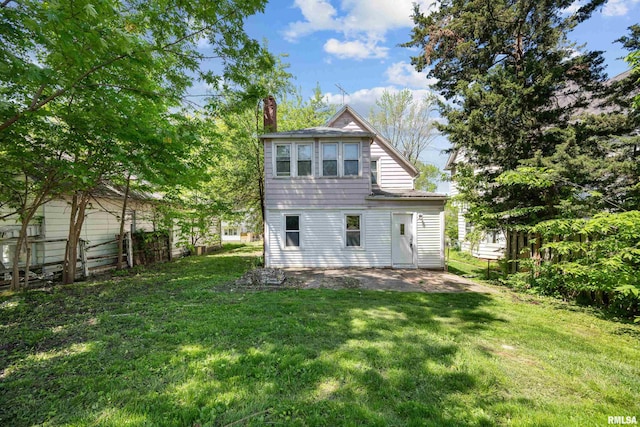 rear view of property featuring a lawn