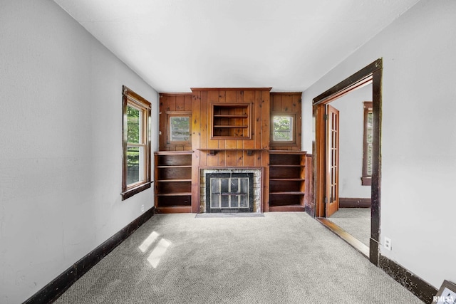 unfurnished living room with carpet and a brick fireplace