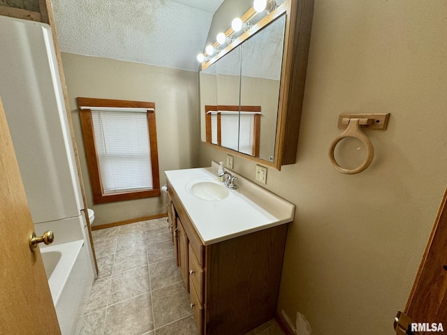 bathroom featuring vanity, a bathtub, tile patterned floors, toilet, and a textured ceiling