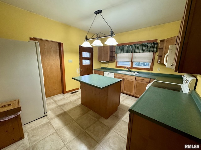 kitchen with a center island, pendant lighting, white appliances, and sink