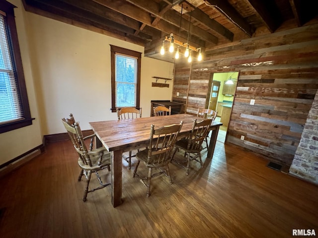 dining area with dark hardwood / wood-style flooring, a wealth of natural light, and wood walls