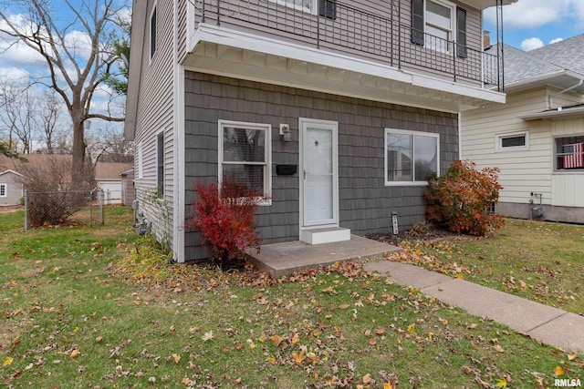 entrance to property featuring a balcony and a yard