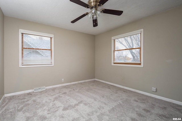 spare room featuring ceiling fan and light colored carpet