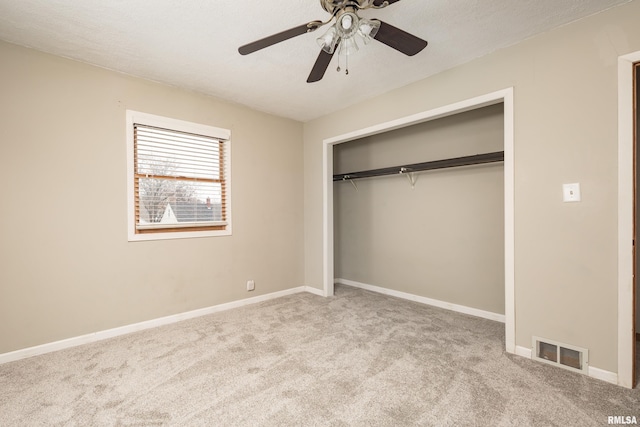 unfurnished bedroom with ceiling fan, a closet, light carpet, and a textured ceiling