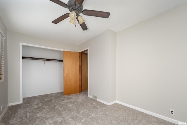 unfurnished bedroom with ceiling fan, a closet, and light carpet