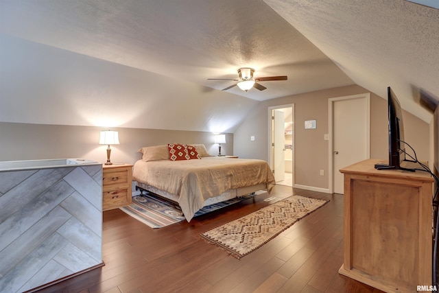 bedroom featuring dark wood-type flooring, ceiling fan, vaulted ceiling, and a textured ceiling