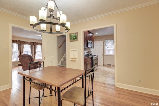 dining space featuring ceiling fan with notable chandelier, ornamental molding, and a textured ceiling