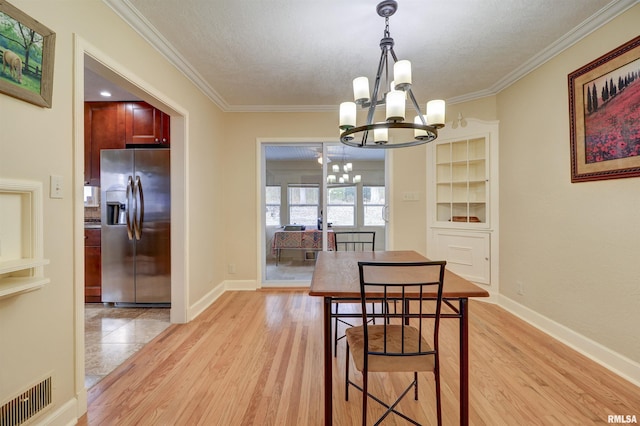 dining area featuring a notable chandelier, crown molding, light hardwood / wood-style floors, and a textured ceiling