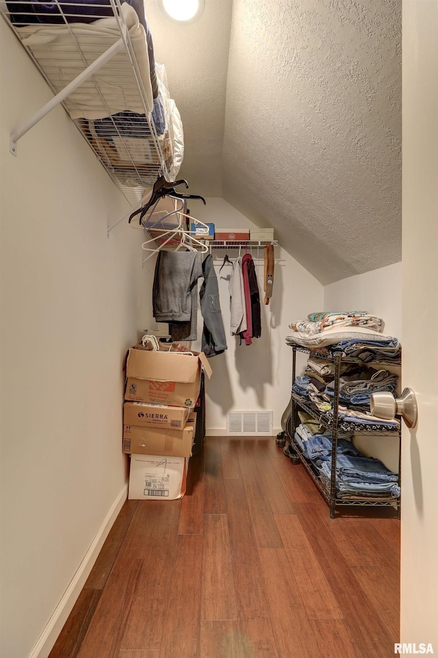 walk in closet featuring hardwood / wood-style flooring and lofted ceiling