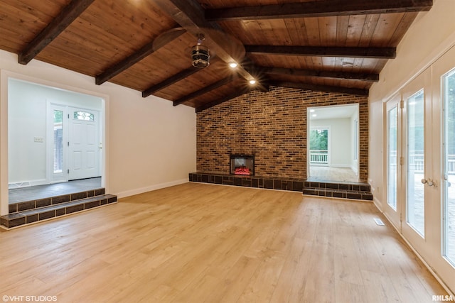 27339 Sherry Ann Ct, Donahue, IA 52746 - unfurnished living room featuring wood-type flooring, wood ceiling, brick wall, a fireplace, and french doors