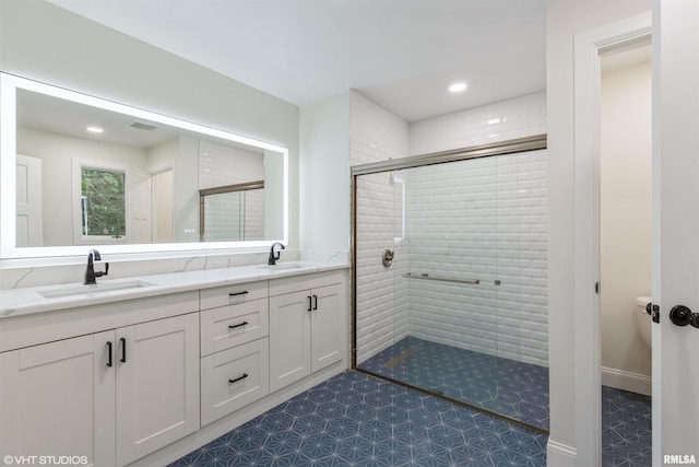 27339 Sherry Ann Ct, Donahue, IA 52746 - full bathroom featuring a stall shower, double vanity, and recessed lighting