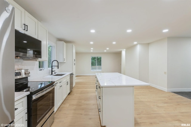 27339 Sherry Ann Ct, Donahue, IA 52746 - kitchen featuring stainless steel appliances, a center island, light wood finished floors, light stone counters, and recessed lighting