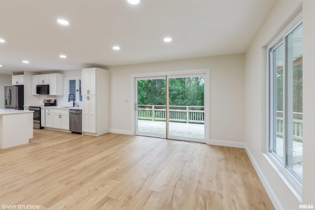 27339 Sherry Ann Ct, Donahue, IA 52746 - kitchen with appliances with stainless steel finishes, light wood-style floors, light countertops, white cabinetry, and recessed lighting