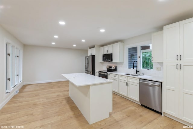 27339 Sherry Ann Ct, Donahue, IA 52746 - kitchen with stainless steel appliances, a center island, white cabinets, tasteful backsplash, and recessed lighting