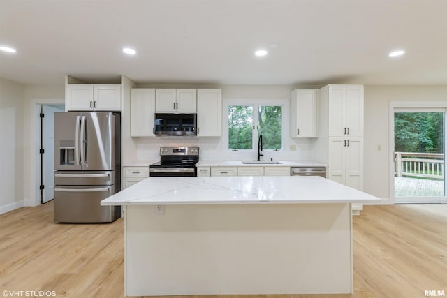 27339 Sherry Ann Ct, Donahue, IA 52746 - kitchen featuring stainless steel appliances, light wood-style floors, white cabinets, plenty of natural light, and recessed lighting