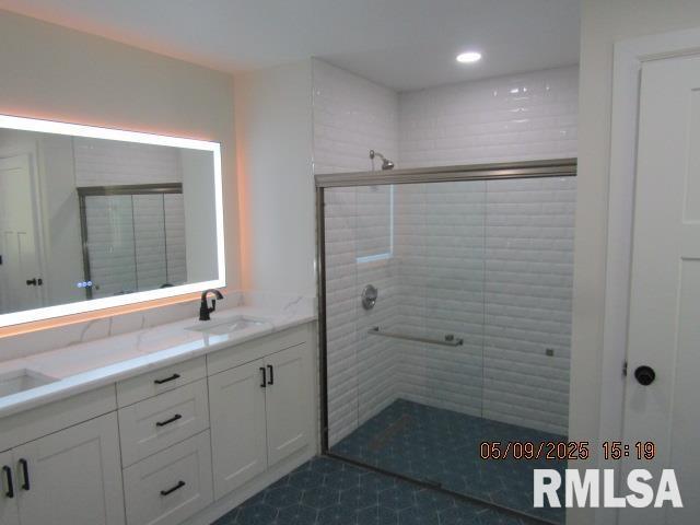 27339 Sherry Ann Ct, Donahue, IA 52746 - full bathroom featuring a shower stall, double vanity, and recessed lighting