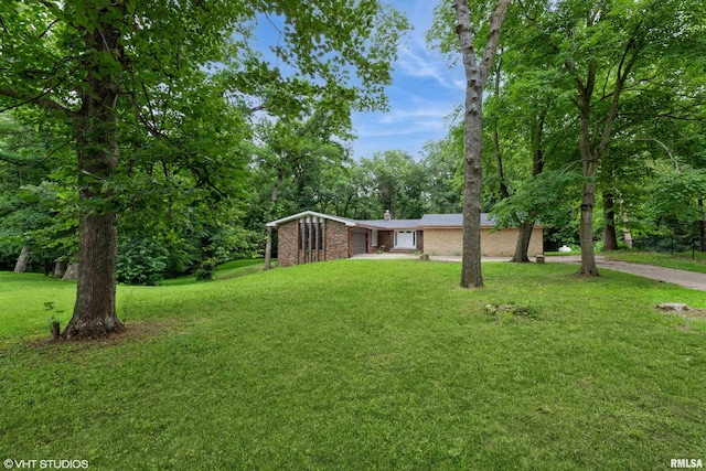 27339 Sherry Ann Ct, Donahue, IA 52746 - view of front of property featuring brick siding, a front lawn, a chimney, and a garage