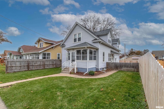 rear view of house featuring a yard and a sunroom