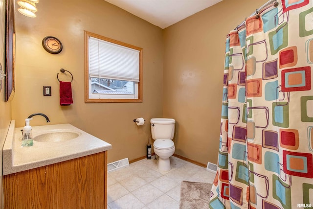 bathroom with tile patterned flooring, vanity, toilet, and walk in shower