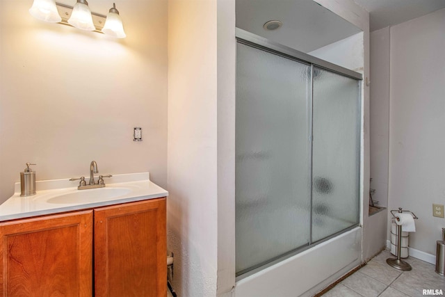 bathroom with tile patterned flooring, bath / shower combo with glass door, and sink