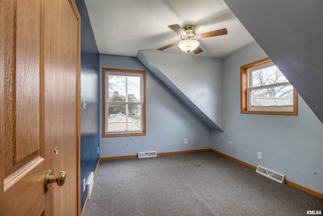 additional living space with ceiling fan, carpet floors, a healthy amount of sunlight, and lofted ceiling